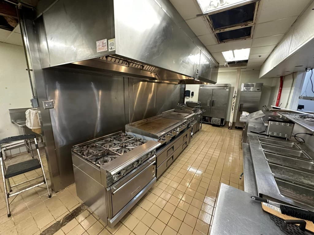 Professionally cleaned commercial kitchen with gleaming stainless steel surfaces